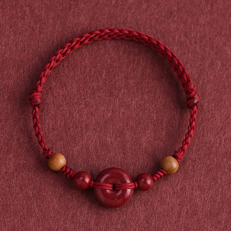 Red String Bracelet with Cinnabar Safety Buckle on a red background